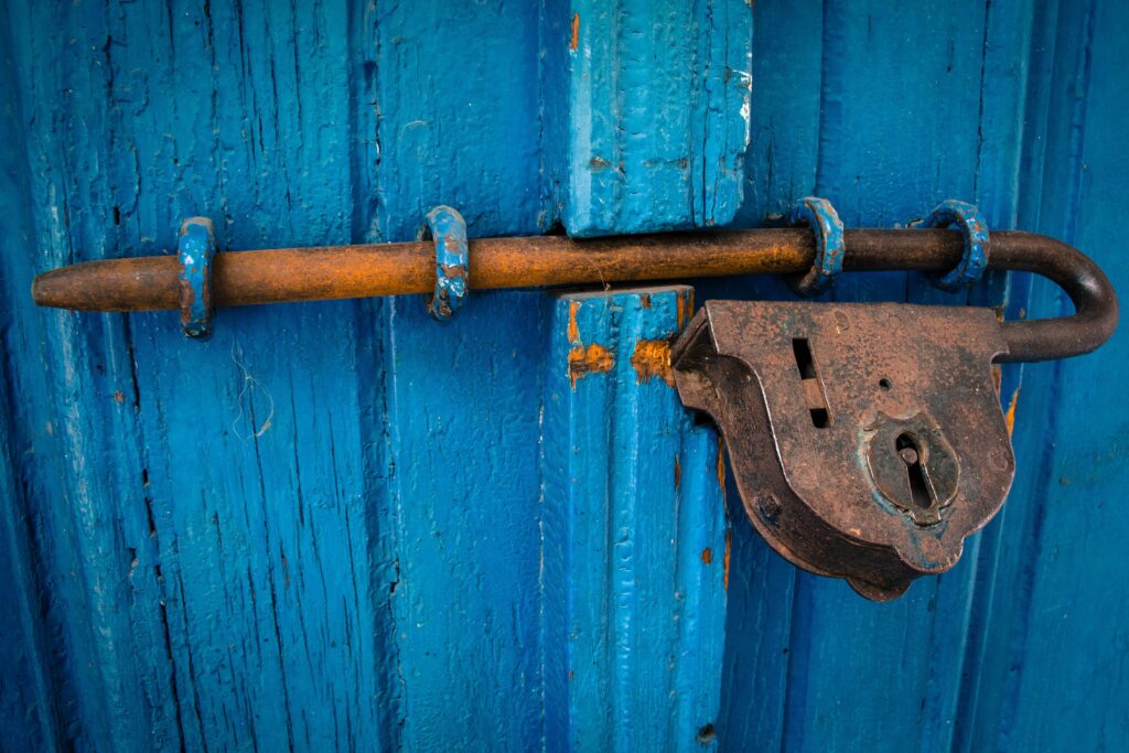 Verrou sur une porte bleue qui résiste à s'ouvrir